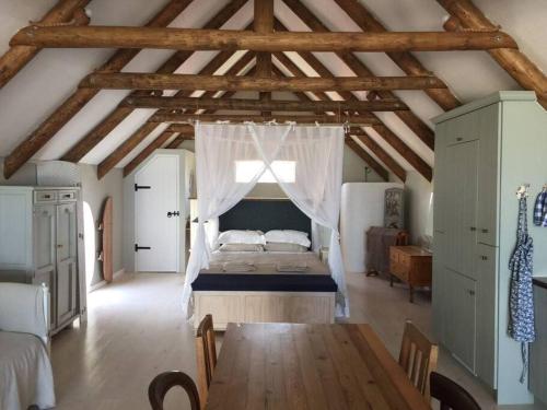 ein Schlafzimmer mit einem Bett und einem Holztisch in der Unterkunft Living The Breede - Infanta Loft in Infanta