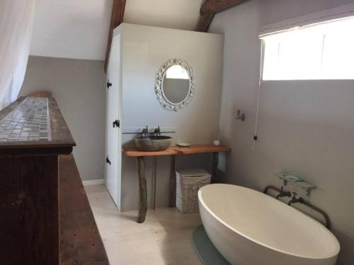 ein Badezimmer mit Badewanne, Waschbecken und Spiegel in der Unterkunft Living The Breede - Infanta Loft in Infanta