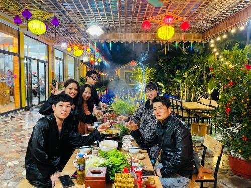 a group of people sitting at a table eating food at Ninh Binh Royal Homestay in Ninh Binh