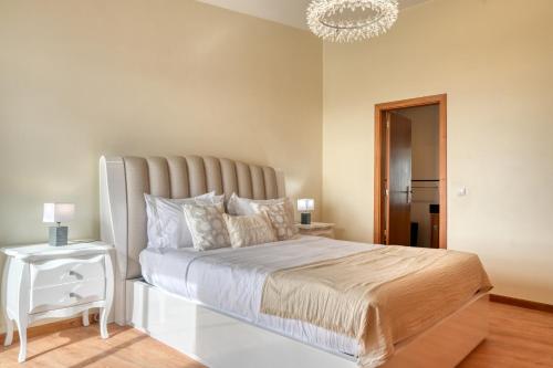 a bedroom with a large bed and a chandelier at Villa 58, a Home in Madeira in Santa Cruz