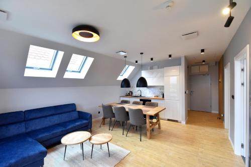 ein Wohnzimmer mit einem blauen Sofa und einem Tisch in der Unterkunft RIVER'S TOUCH Apartament Grand z widokiem na Odrę in Stettin