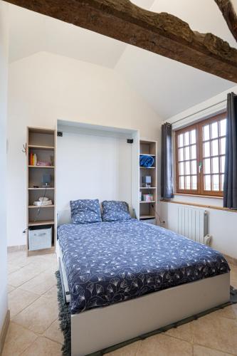 une chambre avec un grand lit avec une couette bleue dans l'établissement La Bouillerie du Manoir des Bréholles, à Goustranville