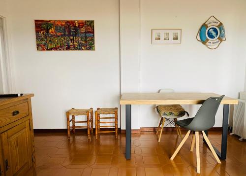 a table in a room with chairs and a painting on the wall at Vistas al Mar in Somo