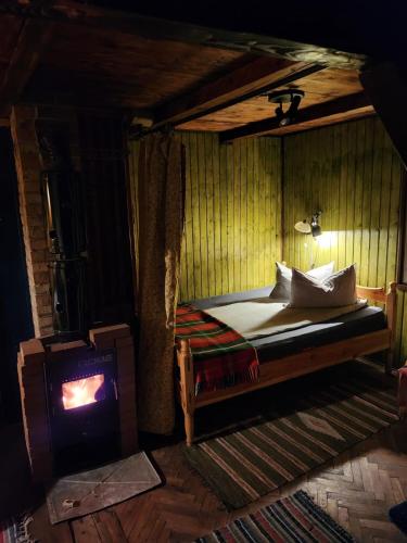 a bedroom with a bed and a stove at Cabana Farmec Ciubăr - Dézsabáj Kulcsosház in Sovata