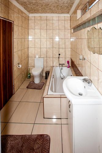 a bathroom with a tub and a toilet and a sink at Invite Guest House - Self Catering Accommodation in Vanderbijlpark in Vanderbijlpark