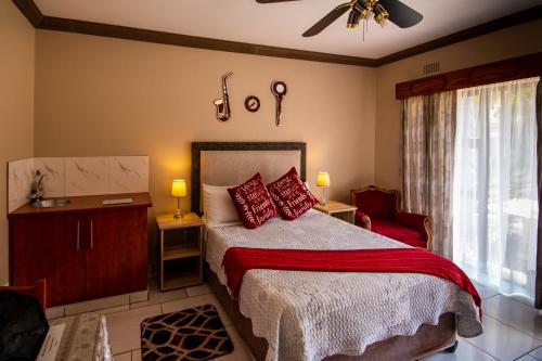 1 dormitorio con 1 cama con almohadas rojas en Invite Guest House Self Catering Accommodation, en Vanderbijlpark