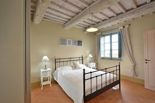 Schlafzimmer mit einem Bett und einem Fenster in der Unterkunft Appartamento Pino in Trequanda