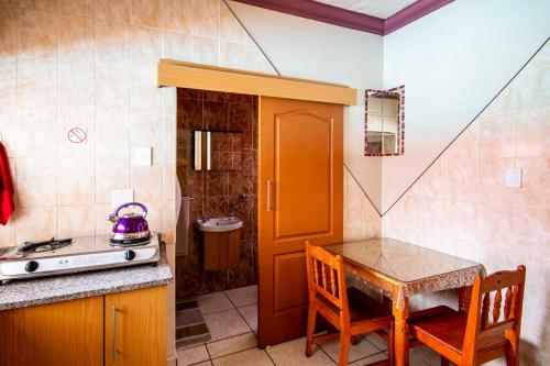 a kitchen with a table and a stove and a sink at Invite Guest House Self Catering Accommodation in Vanderbijlpark
