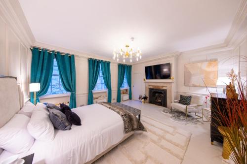 sypialnia z białym łóżkiem i niebieskimi zasłonami w obiekcie Haus of Mason w Londynie