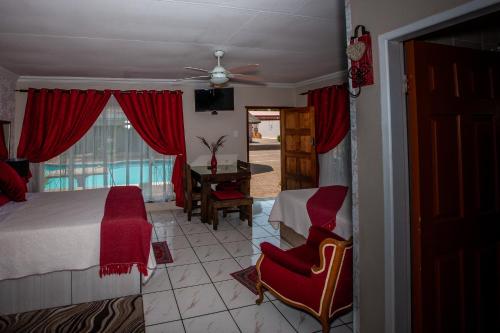 a bedroom with a bed and a chair and a window at Invite Guest House - Self Catering Accommodation in Vanderbijlpark in Vanderbijlpark