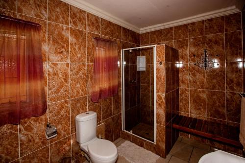 a bathroom with a toilet and a shower at Invite Guest House - Self Catering Accommodation in Vanderbijlpark in Vanderbijlpark