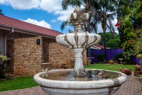 a fountain in the yard of a house at Invite Guest House - Self Catering Accommodation in Vanderbijlpark in Vanderbijlpark