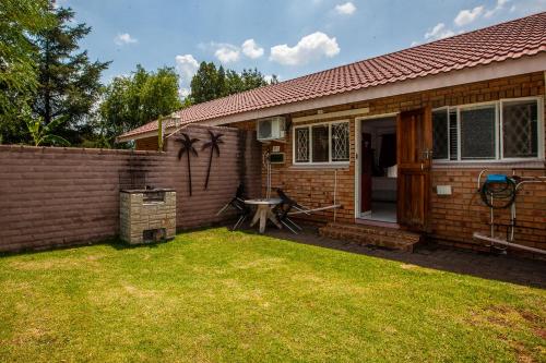 a house with a fence and a yard at Invite Guest House - Self Catering Accommodation in Vanderbijlpark in Vanderbijlpark