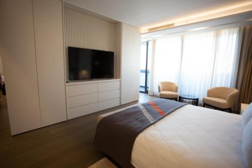 een hotelkamer met een bed en een flatscreen-tv bij EN Hotel Boutique Izmir in Konak