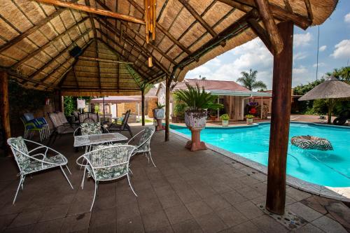 a patio with a table and chairs next to a pool at Invite Guest House - Self Catering Accommodation in Vanderbijlpark in Vanderbijlpark