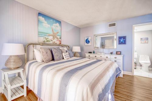 默特爾海灘的住宿－Sunset Coral，一间蓝色卧室,配有一张床和镜子