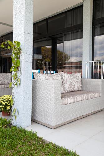 a white bench on the side of a building at Pousada Guaricana in Pontal do Paraná