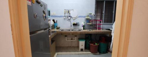 een kleine keuken met een wastafel en een koelkast bij DSAF Family Homestay Pandan Indah in Ampang