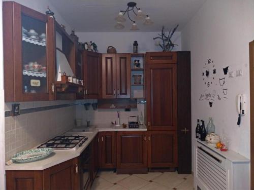 a kitchen with wooden cabinets and a stove top oven at Bilocale e Monolocale Patrizia in Rio Marina