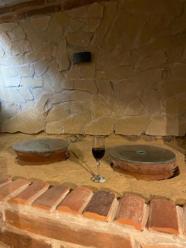 a glass of wine sitting next to a stone wall at CHOGO in Kutaisi