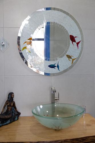 a bathroom with a glass bowl sink and a mirror at Pousada Guaricana in Pontal do Paraná