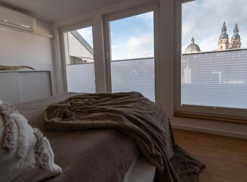a bedroom with a bed and a large window at St. Salvator Apartments in Fulda