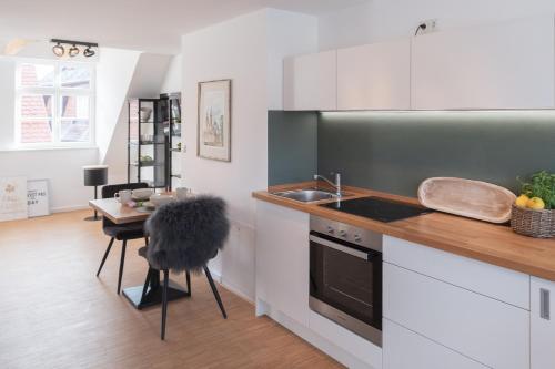a kitchen with a sink and a stove and a table at St. Salvator Apartments in Fulda