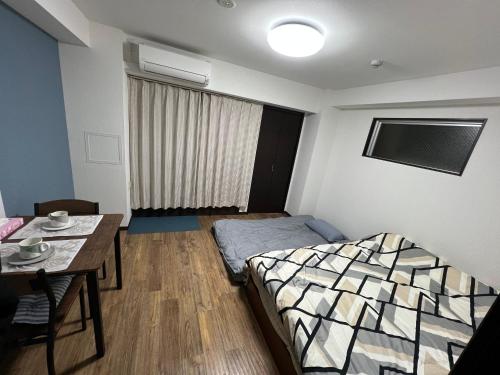 a small room with a bed and a table at shizuka1 501 in Osaka