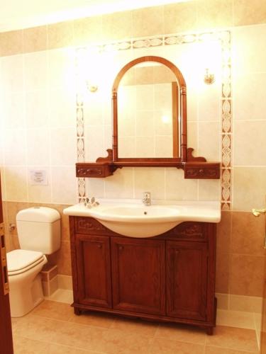 a bathroom with a sink and a toilet and a mirror at Hotel Archontiko Dimitra in Vergina