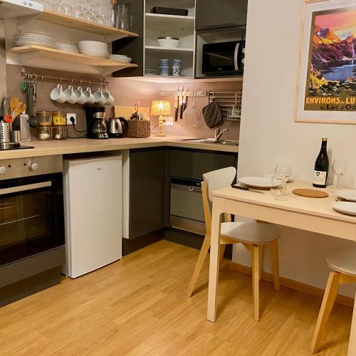 une cuisine avec une table et une salle à manger dans l'établissement Newly Renovated Ground Floor Apartment close to Thermes, à Luchon
