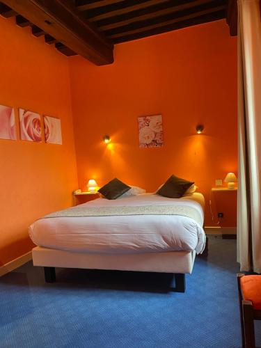 a bedroom with an orange wall with a bed at Hostellerie Du Chateau in Châteauneuf