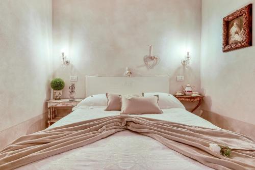 a bedroom with a large white bed with pink pillows at Casa Monella in La Spezia
