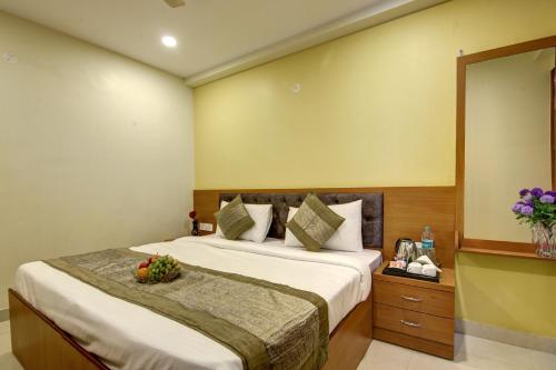 a bedroom with a large bed and a mirror at Hotel TMS Grand in New Delhi