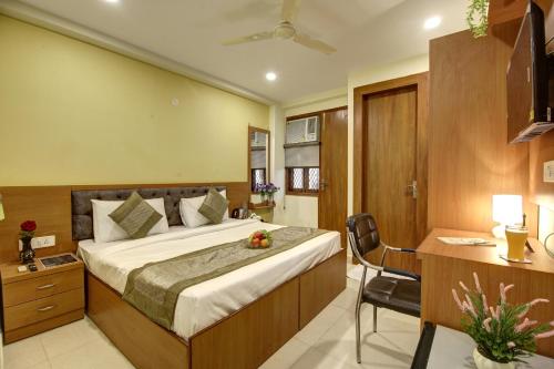 a hotel room with a bed and a desk at Hotel TMS Grand in New Delhi