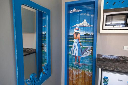 a door with a painting of a woman on it at Pousada Guaricana in Pontal do Paraná
