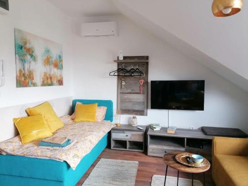 een woonkamer met een bank en een flatscreen-tv bij Jarun Apartman "Runolist" in Zagreb