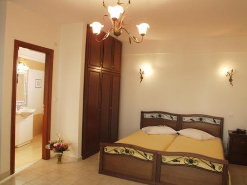 a bedroom with a bed and a chandelier at Hotel Archontiko Dimitra in Vergina