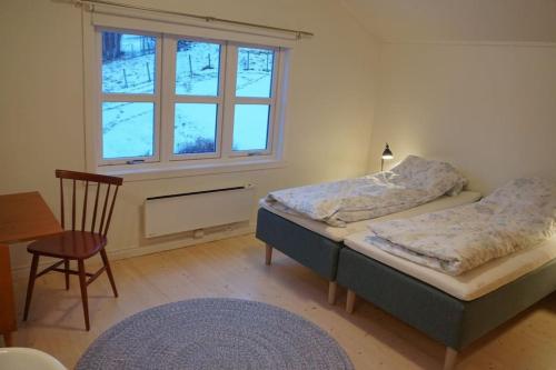 a bedroom with two beds and a window at Moonvalley Lodge - stort & koselig hus - Måndalen in Sæbø