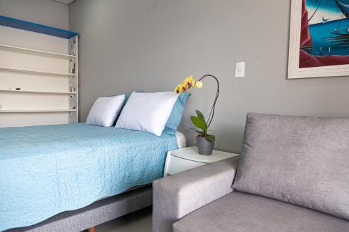 a bedroom with a bed and a couch and a chair at Pousada Guaricana in Pontal do Paraná