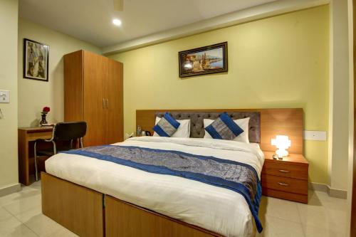 a bedroom with a large bed and a desk at Hotel TMS Grand in New Delhi