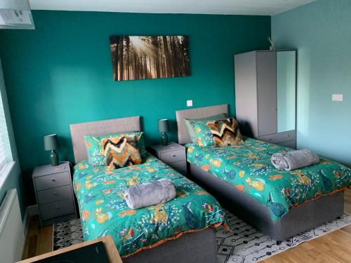 1 Schlafzimmer mit 2 Betten und einer grünen Wand in der Unterkunft Walnut Lodge, Timberland in Martin