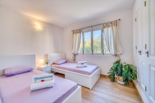 Ideal Property Mallorca - Villa Jardi في الكوذيا: غرفة نوم بسريرين ونافذة