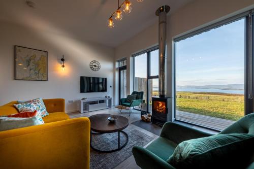 a living room with a couch and chairs and a fireplace at Silverwood Waternish in Portree