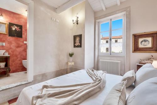 a white bedroom with a bed and a window at Casa Monella in La Spezia