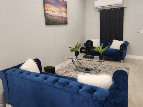 a blue couch with white pillows in a living room at The Hide Away in Nassau