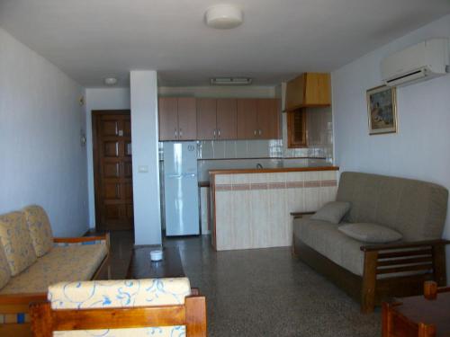 un soggiorno con divano e una cucina di Apartamentos Llevant a Ibiza Città