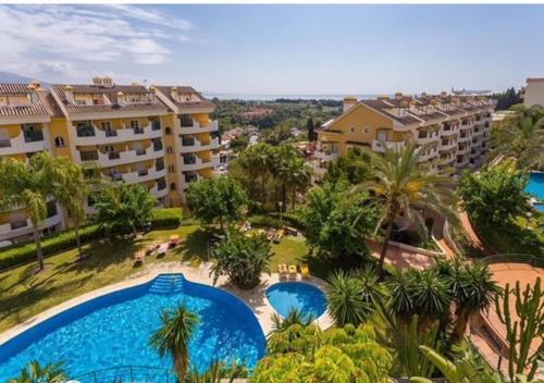 einen Luftblick auf ein Resort mit zwei Pools und Palmen in der Unterkunft Walking distance to Puerto Banus sea view Apartment in Marbella