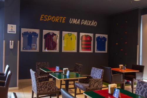 a restaurant with tables and chairs and pictures on the wall at Quality Hotel & Suítes São Salvador in Salvador