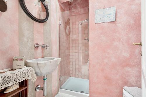 a pink bathroom with a sink and a shower at Casa Monella in La Spezia