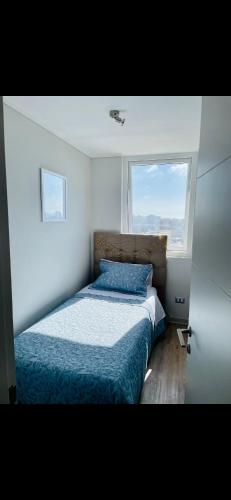 a bedroom with a bed with a large window at Hermoso departamento Viña del Mar in Viña del Mar